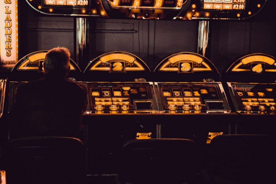 Seorang pria berjudi di mesin slot di sebuah arcade hiburan.