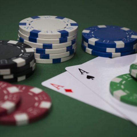 Dua kartu as di antara beberapa tumpukan chip poker.